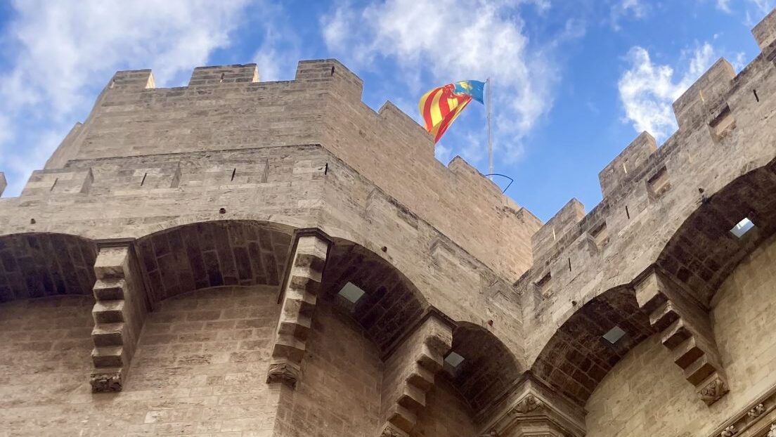A Valencian flag flies on the stonework of Valencia's historic Torres Serranos