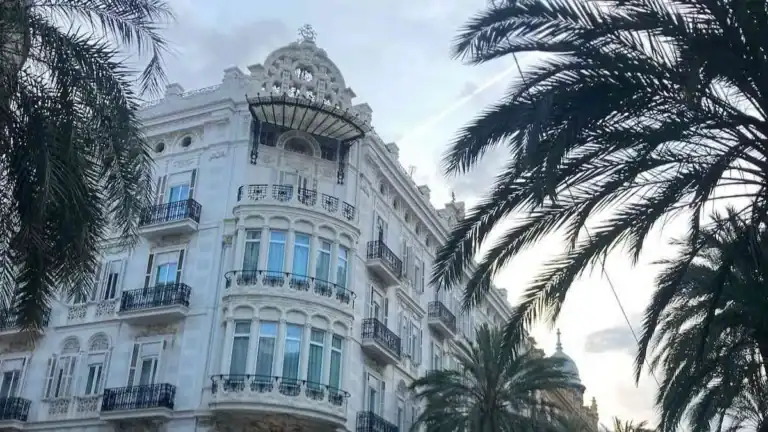 White art deco building in La Seu neighborhood of Valencia framed by palm trees