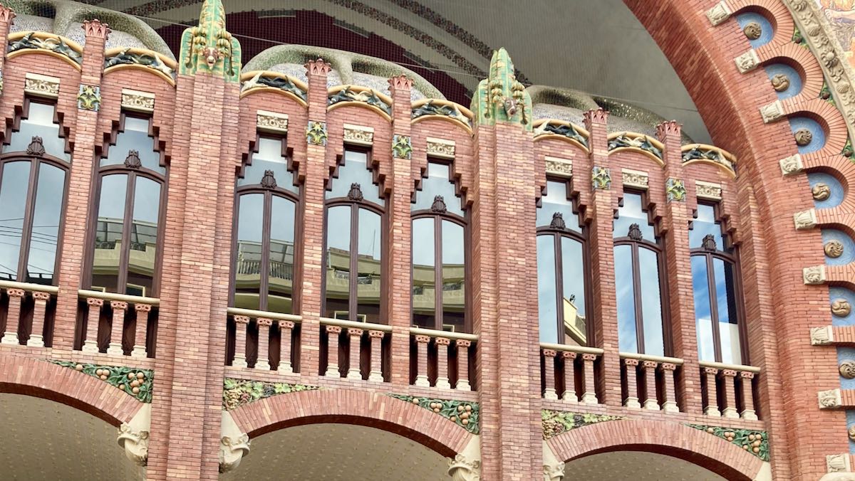The brick and glass modernist facade of Mercado Colon in Valencia