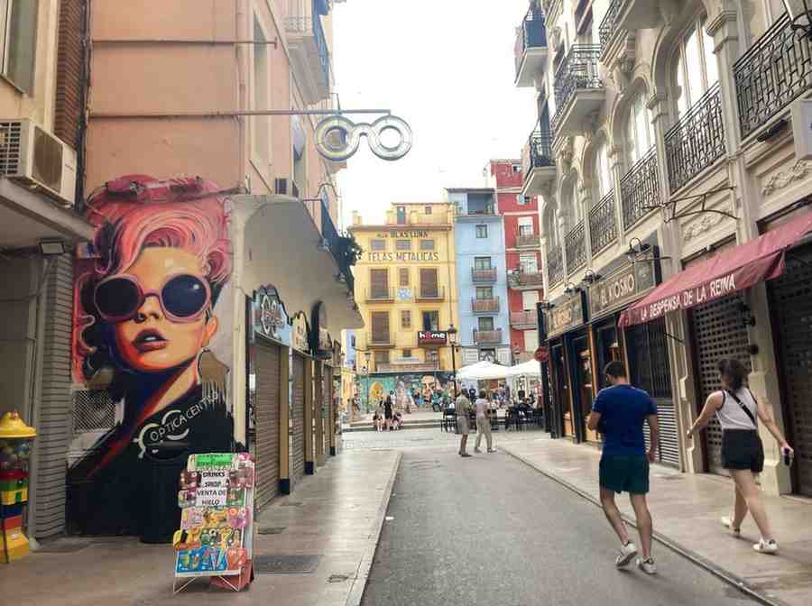 Urban street art of a girl with pink hair and sunglasses on a Valencia street