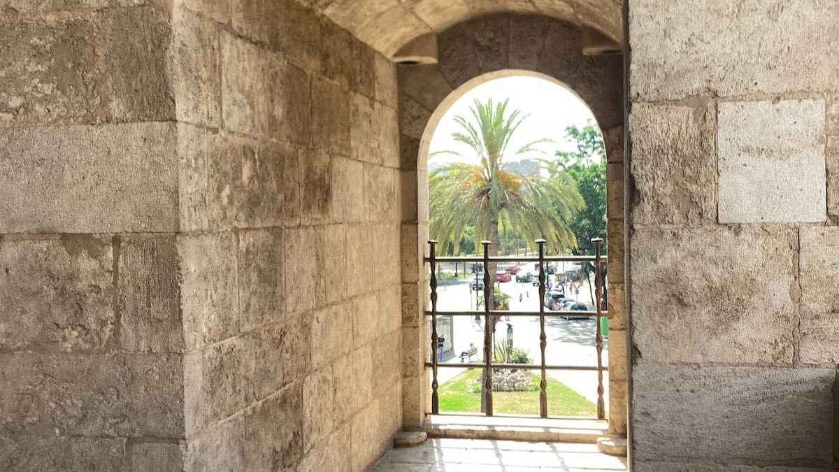 An arched window with a view of the street from inside the historic Torres Serranos in Valencia