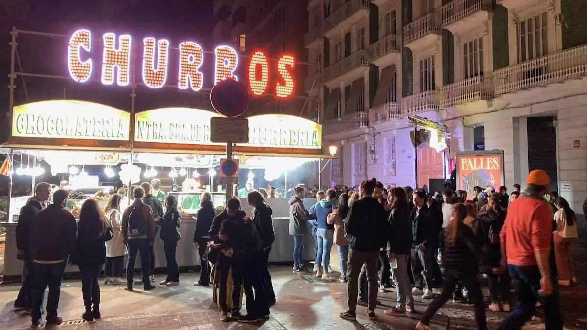A churros stand crowded with customers one night in Fallas