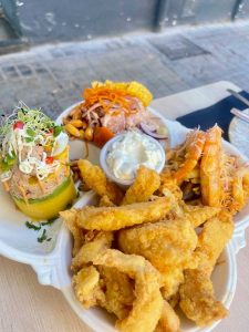 A plate of mixed seafood, including Peruvian food specialties like ceviche and causa