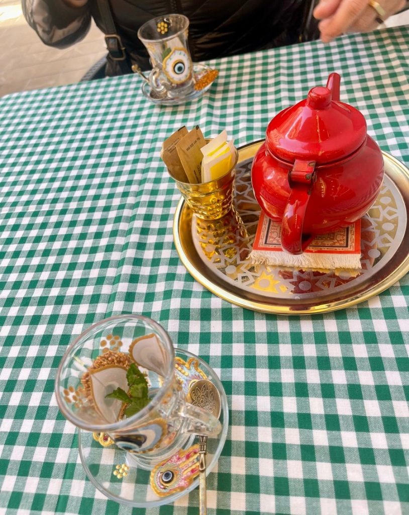 Red teapot and Ukrainian glass tea cups on green and white checkered cloth