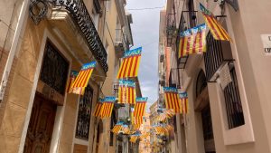 yellow, red and blue Valencia flags strung up over a street