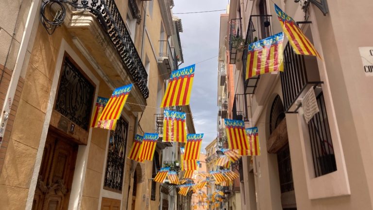 yellow, red and blue Valencia flags strung up over a street