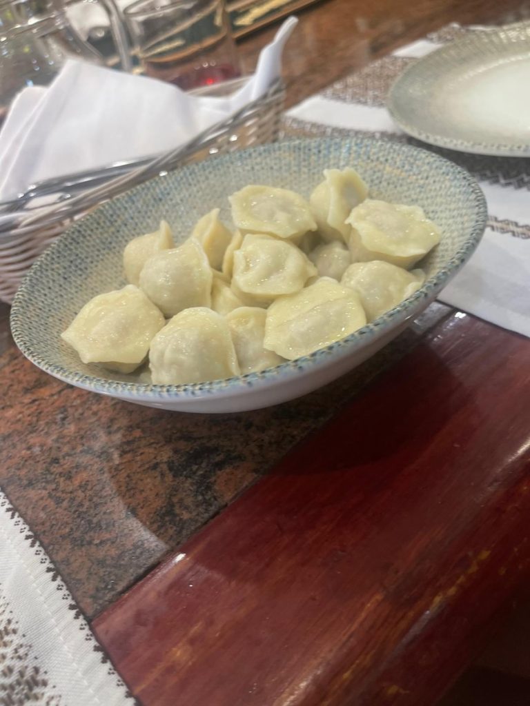 A bow of white Ukrainian dumplings on a wood table
