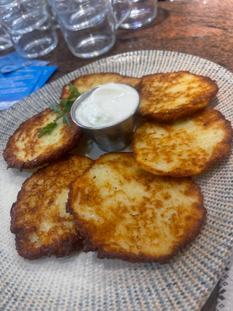 A plate of potato pancakes with cream