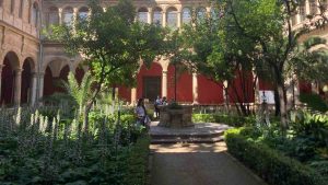 A garden courtyard with green plants and pillars inside the Carmen Contemporary Culture Center in Valencia, Spain