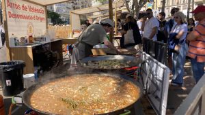 A large pan of paella simmering in an outdoor stall