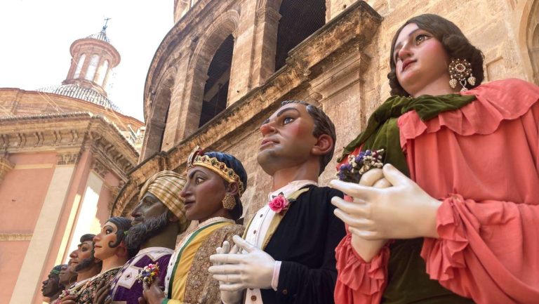 Large-scale life-like puppets in elaborate costumes, known as "gigantes" or giants, on display by the Cathedral of Valencia for the festival of Corpus Christi.