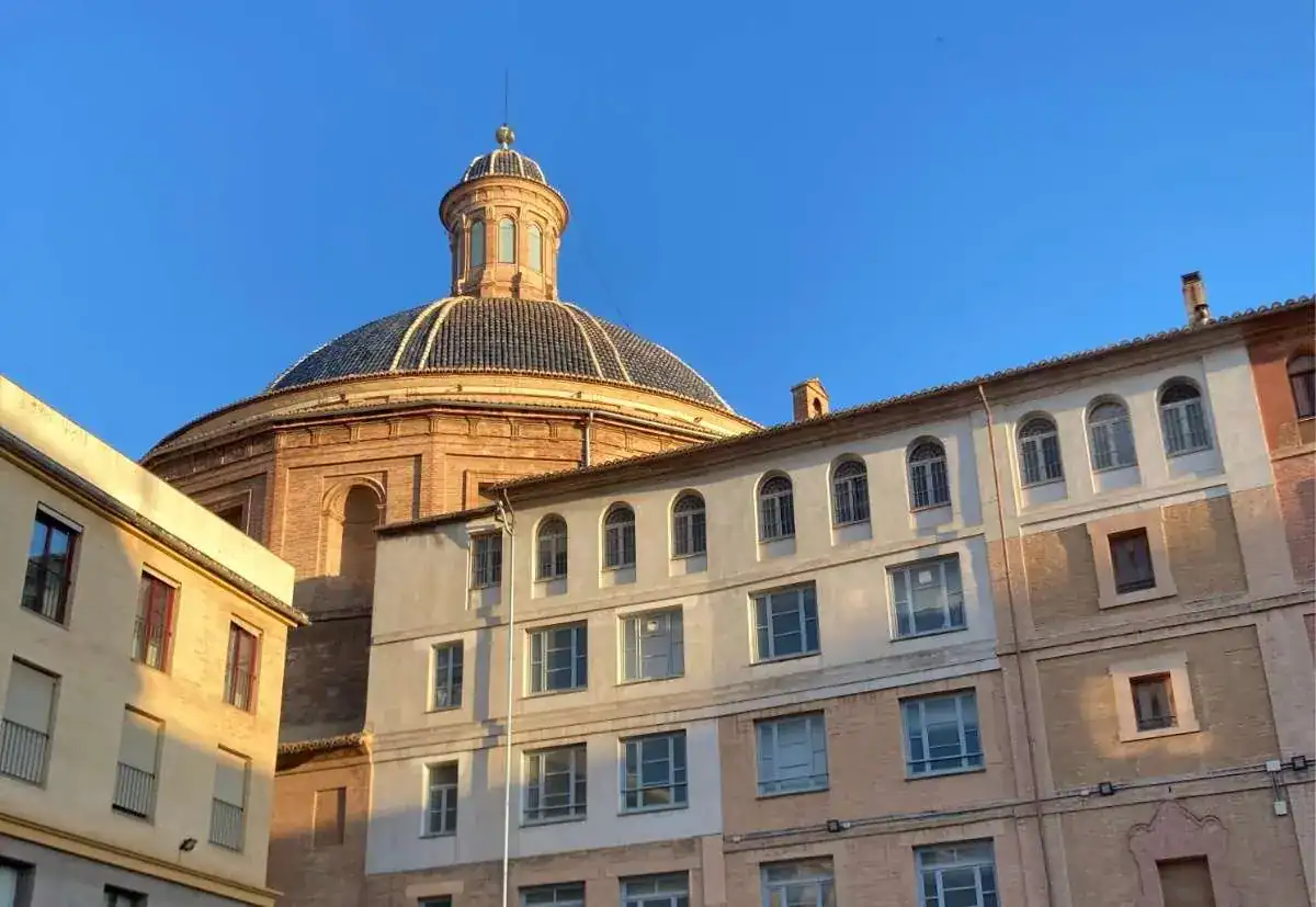The blue-tiled cupola of the Church of San Joaquin rising over the windows of the Escuelas Pias school.