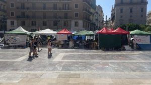 Pedestrians walk past a row of tents erected in Plaza de la Virgen as part of a teachers strike to improve working conditions in Valencia, Spain.