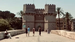 Valencia's iconic Serrano Towers in the summer with a guitarist busking at the bridge