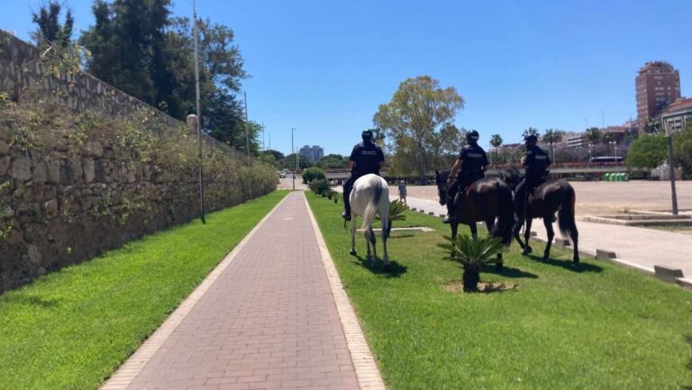 3 police on horseback walk along an empty path in the Turia park