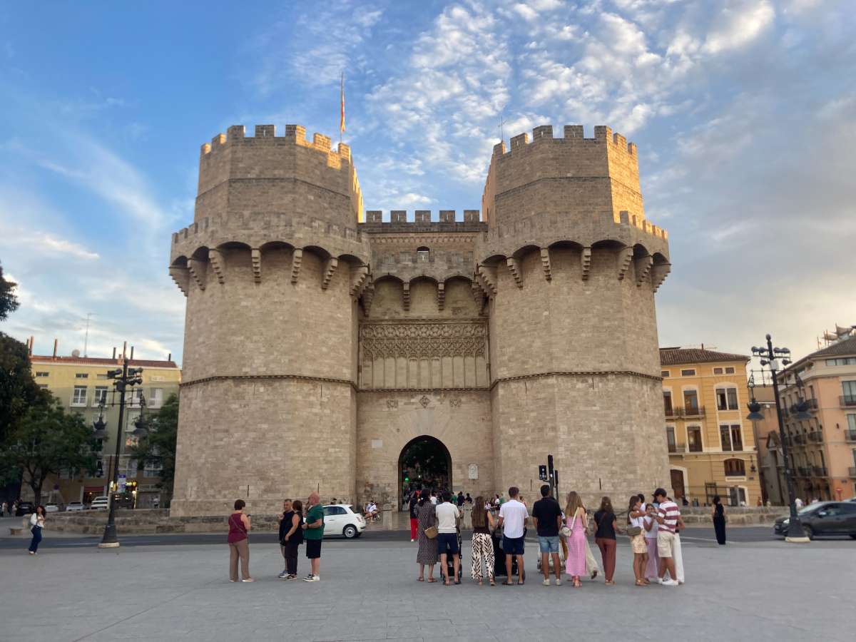 Valencia's Torres Serranos at sunset with tourists in front